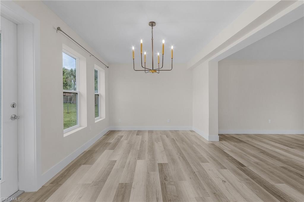 Unfurnished dining area featuring an inviting chandelier and light hardwood / wood-style floors
