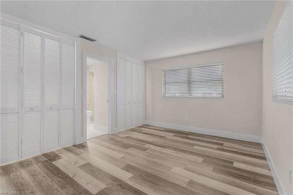 Unfurnished bedroom featuring ensuite bathroom and light hardwood / wood-style floors