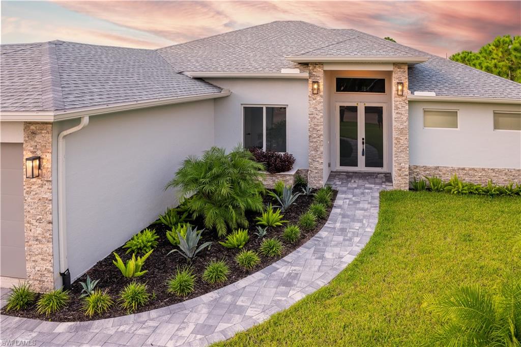Exterior entry at dusk with french doors and a yard