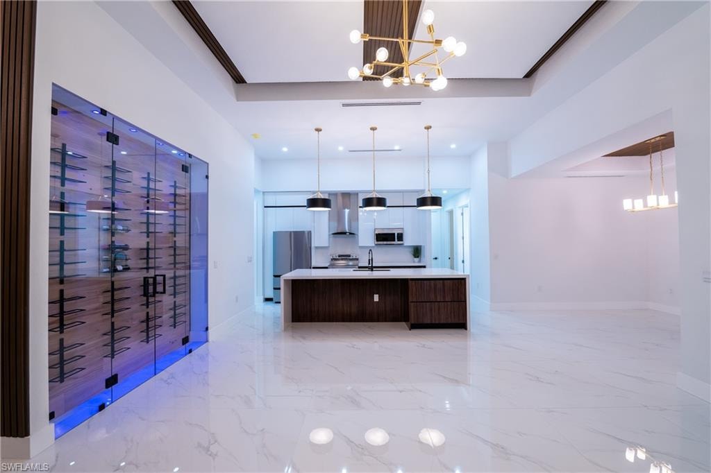 Kitchen with pendant lighting, a notable chandelier, and a spacious island