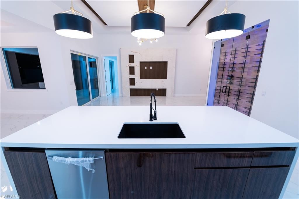 Kitchen featuring pendant lighting, sink, and a center island with sink