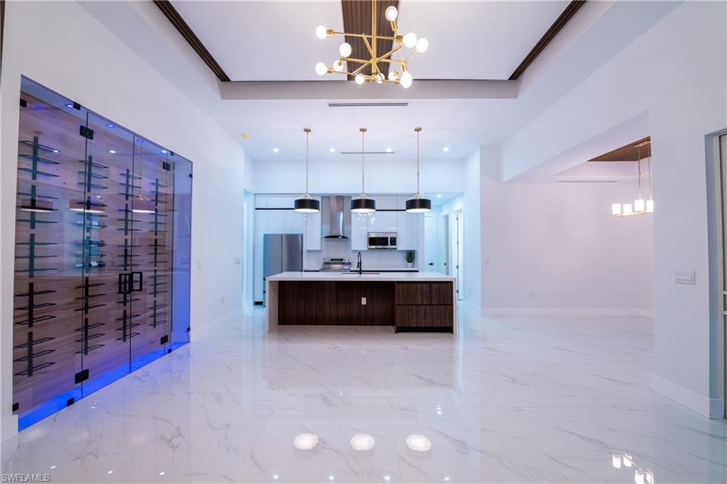 Kitchen featuring a large island, decorative light fixtures, stainless steel appliances, and a chandelier