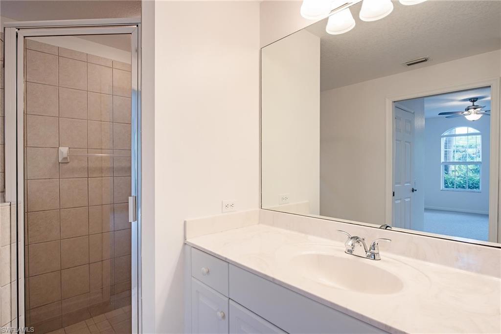 Bathroom with vanity, ceiling fan and walk in shower