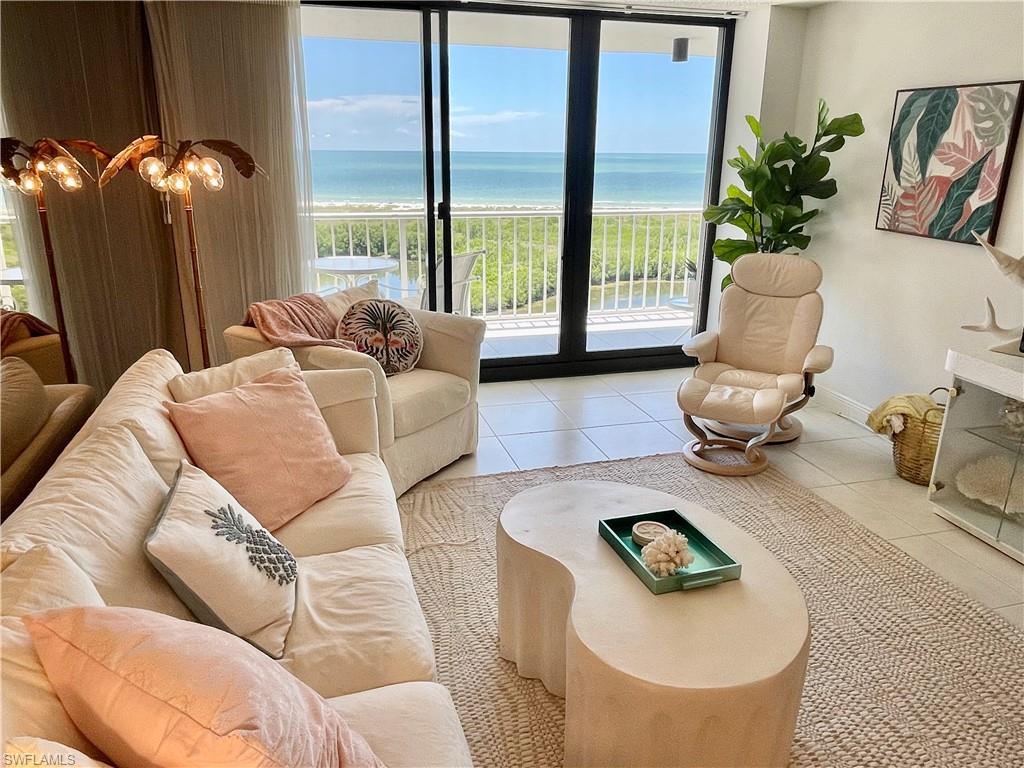 Living room featuring light tile patterned flooring and a water view