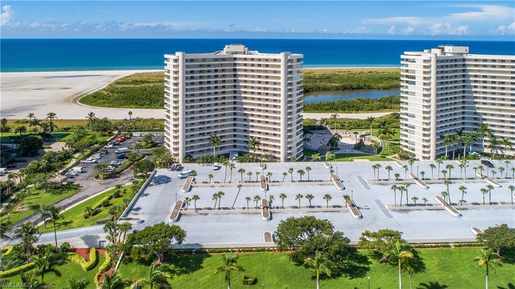 Birds eye view of property featuring a water view and a view of the beach
