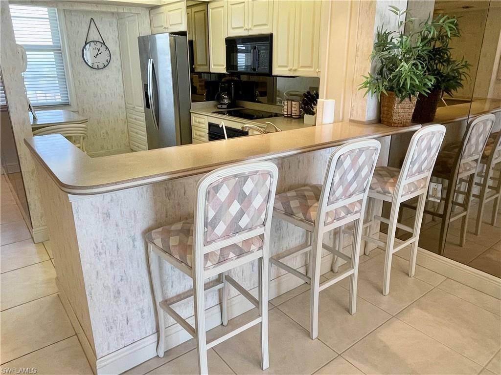 Kitchen with a breakfast bar, kitchen peninsula, and black appliances