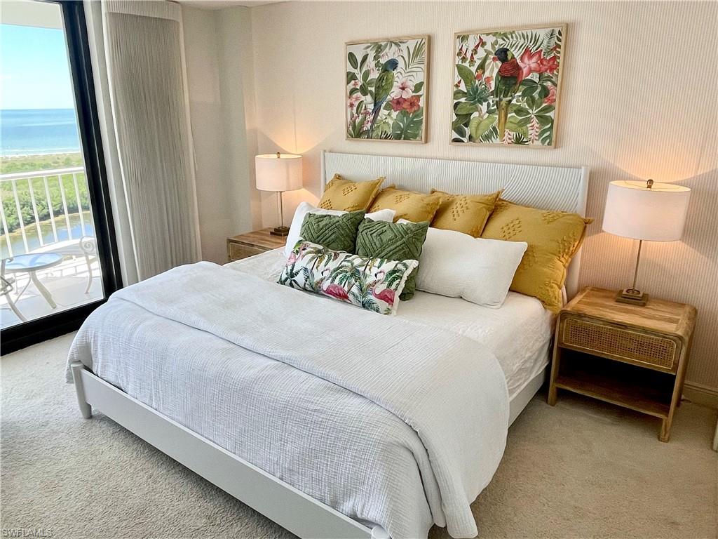 Carpeted bedroom featuring a water view and access to exterior
