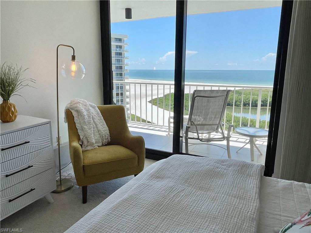 Carpeted bedroom with a water view, access to exterior, and multiple windows