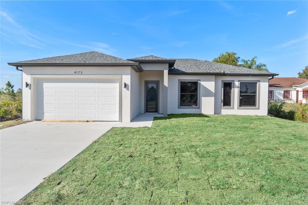 Prairie-style house featuring an attached garage, concrete driveway, a front yard, and stucco siding