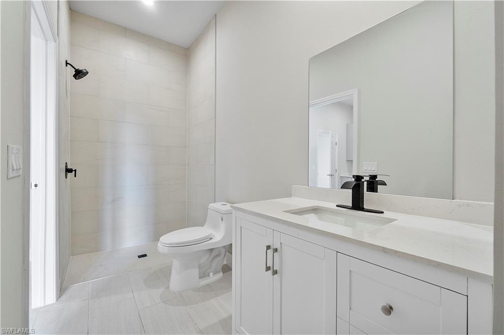 Bathroom with vanity, toilet, and tile patterned floors