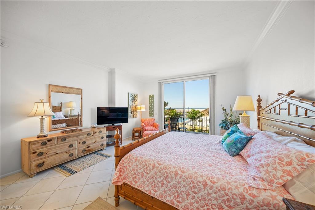Tiled bedroom featuring crown molding and access to outside
