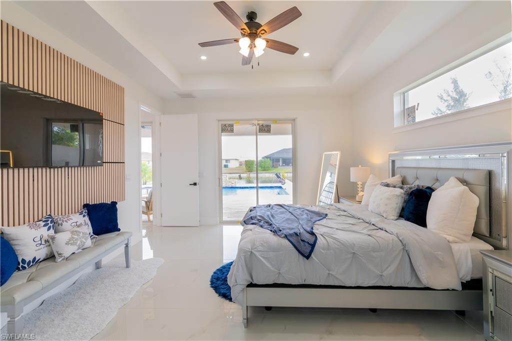 Bedroom featuring access to exterior, a raised ceiling, a ceiling fan, and recessed lighting