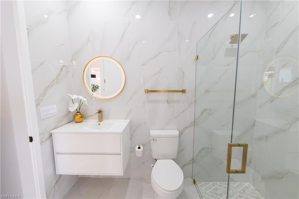 Full bathroom with vanity and a marble finish shower