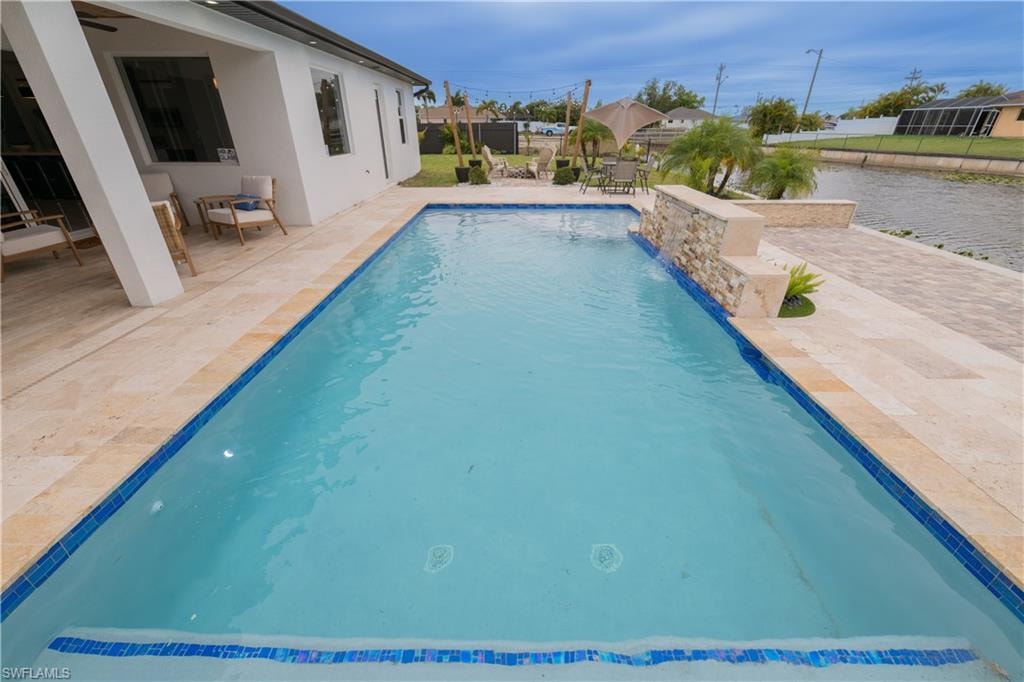 Outdoor pool with a patio area and outdoor dining space