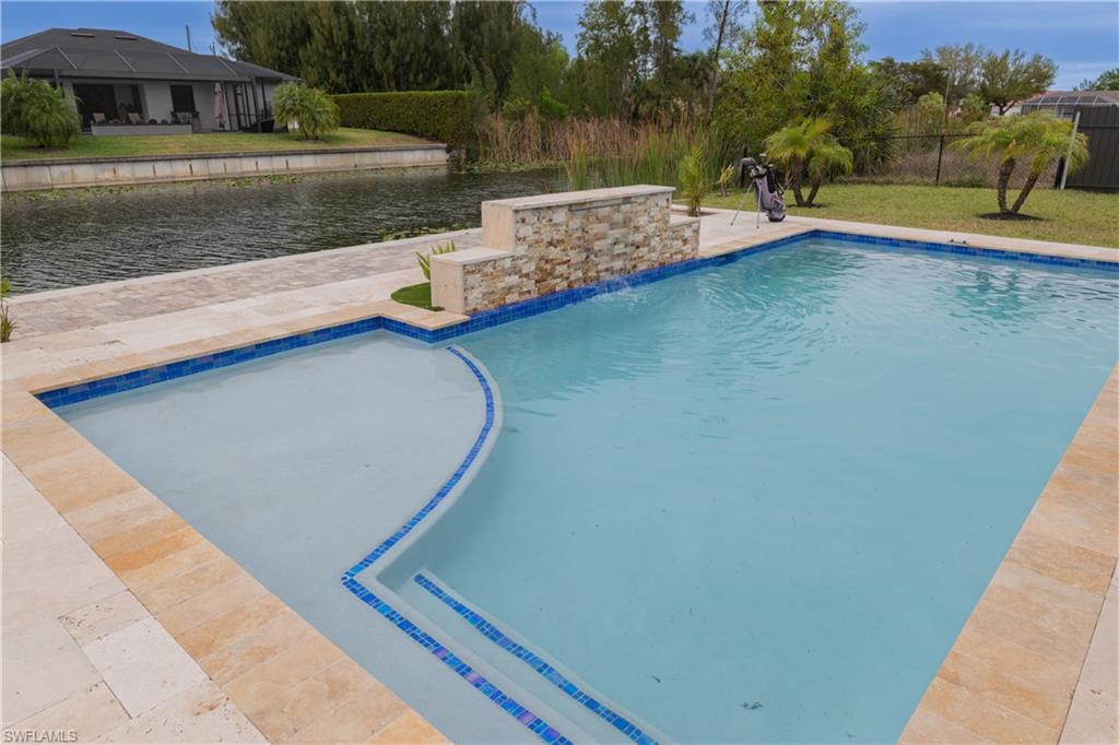 View of pool featuring patio surround and a water view