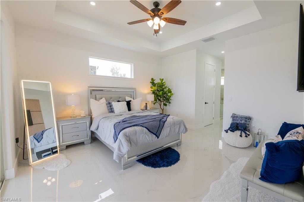 Bedroom with a tray ceiling, a ceiling fan, recessed lighting, and a closet