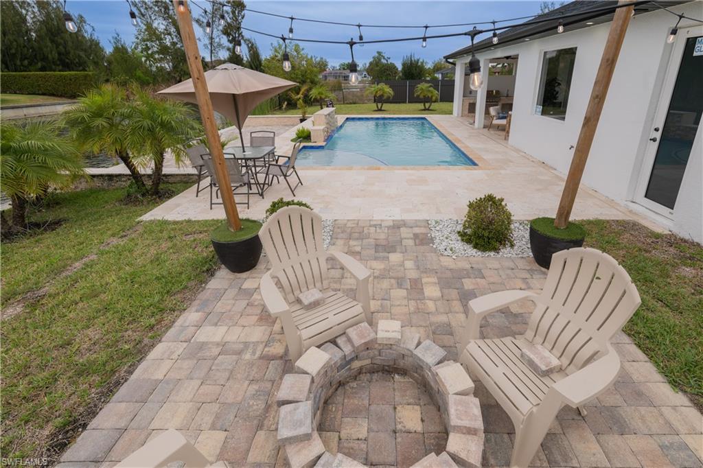 Outdoor pool with a patio area, a fenced backyard, and outdoor dining space