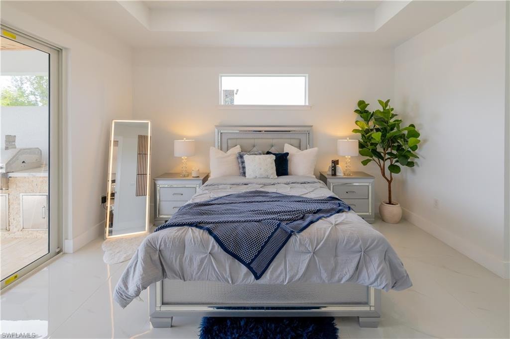 Bedroom with a raised ceiling and access to outside