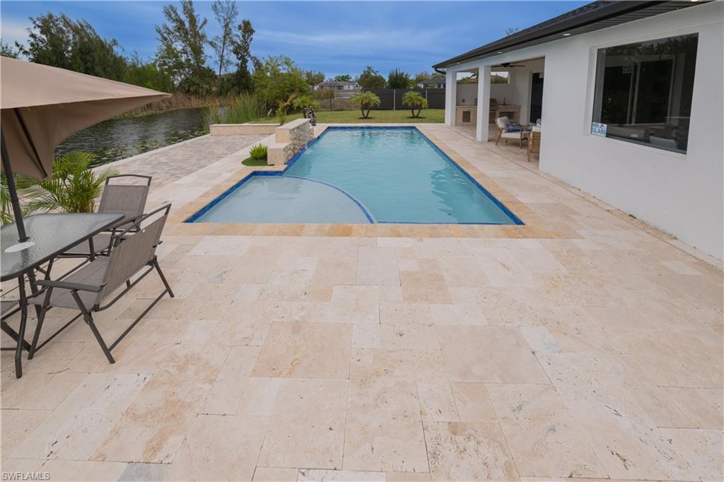 Outdoor pool with a patio, outdoor dining space, and a fenced backyard