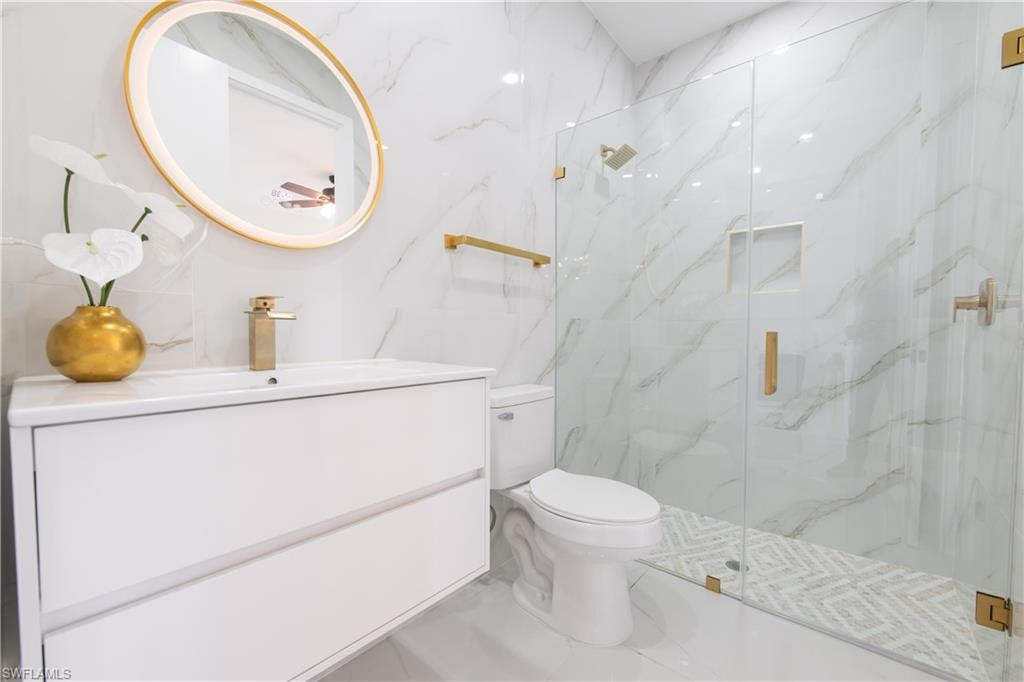 Full bath with vanity and a marble finish shower