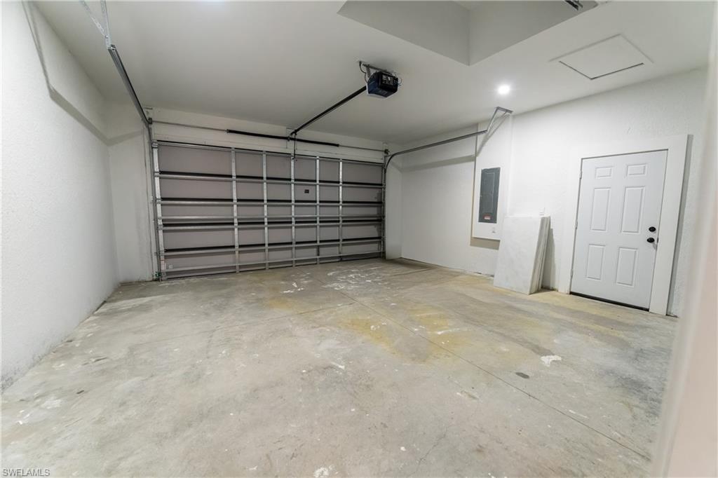 Garage featuring a garage door opener and electric panel