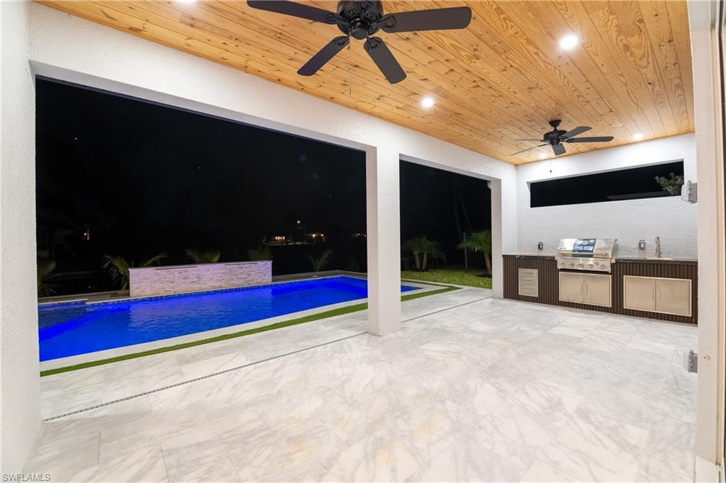 View of pool with sink and grilling area