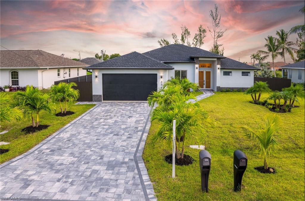 View of front of house with a garage and a lawn