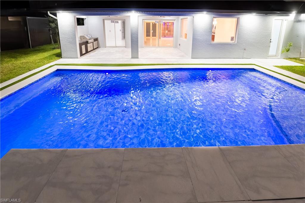 View of swimming pool with area for grilling and a patio area