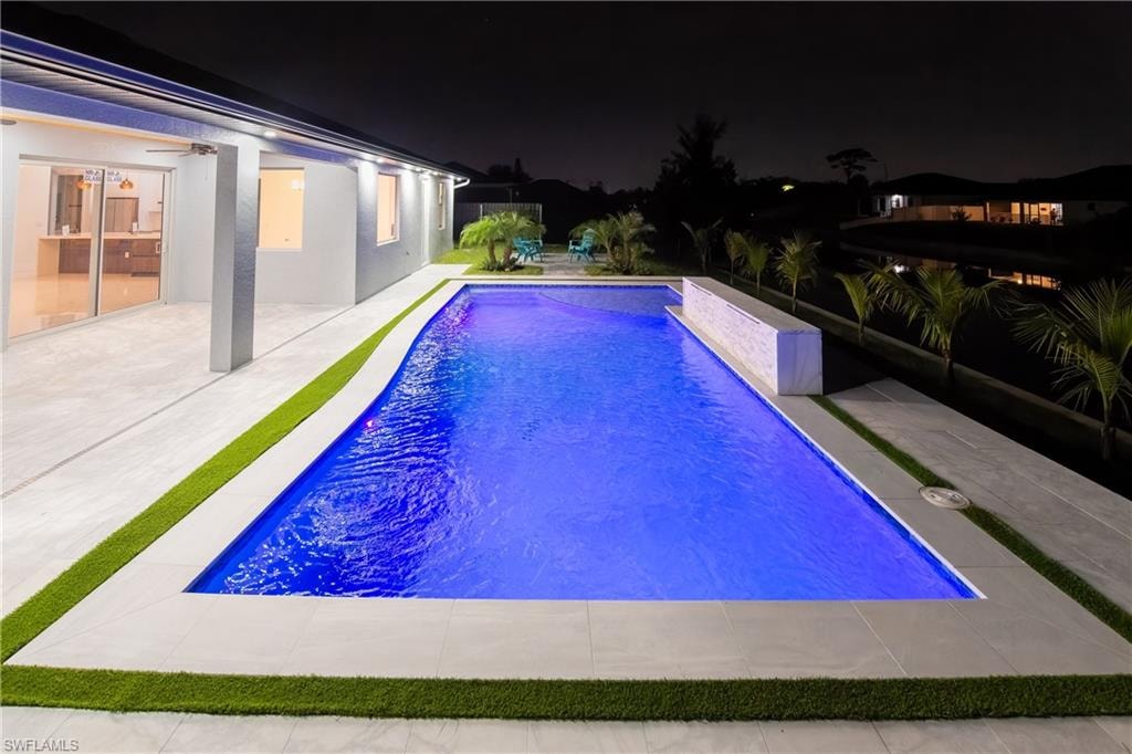 Pool at twilight with a patio area