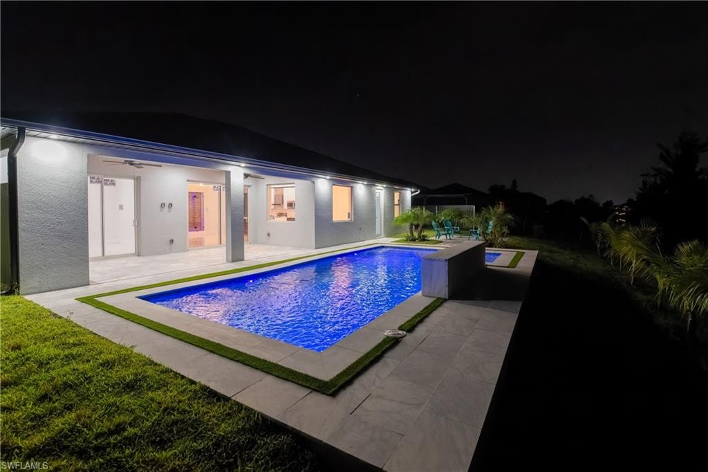 Pool at twilight featuring a patio and ceiling fan