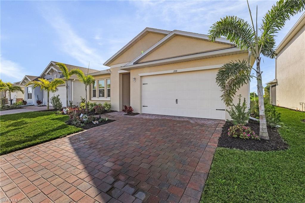 Ranch-style house featuring a garage and a front lawn