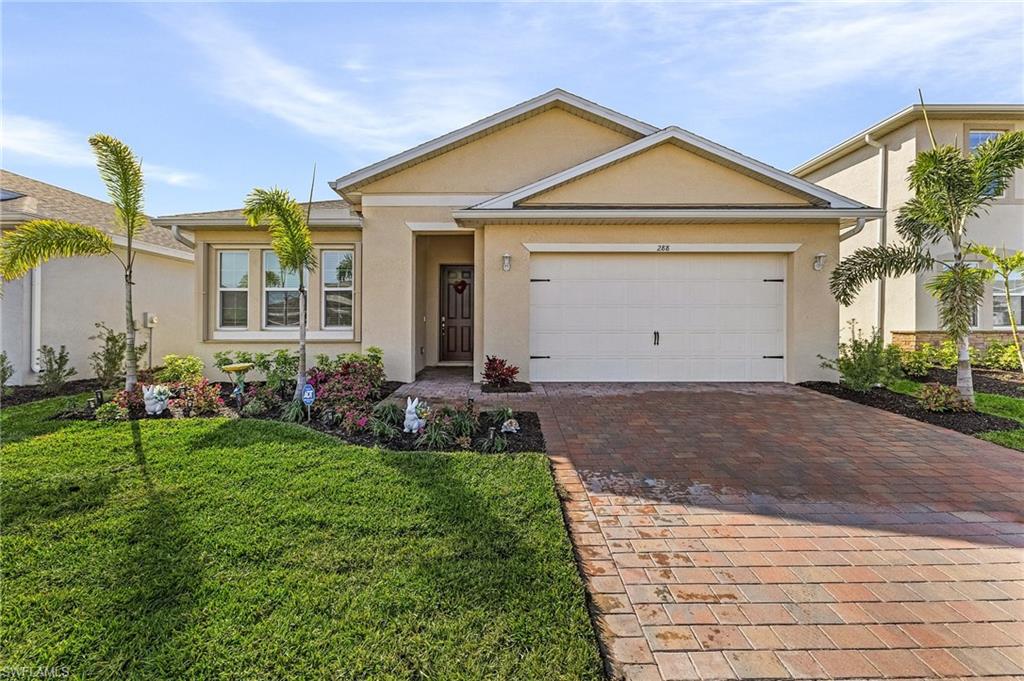 Ranch-style house featuring a garage and a front lawn