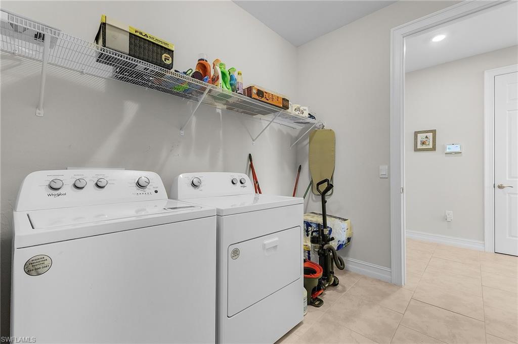 Laundry room with light tile patterned floors and washing machine and dryer