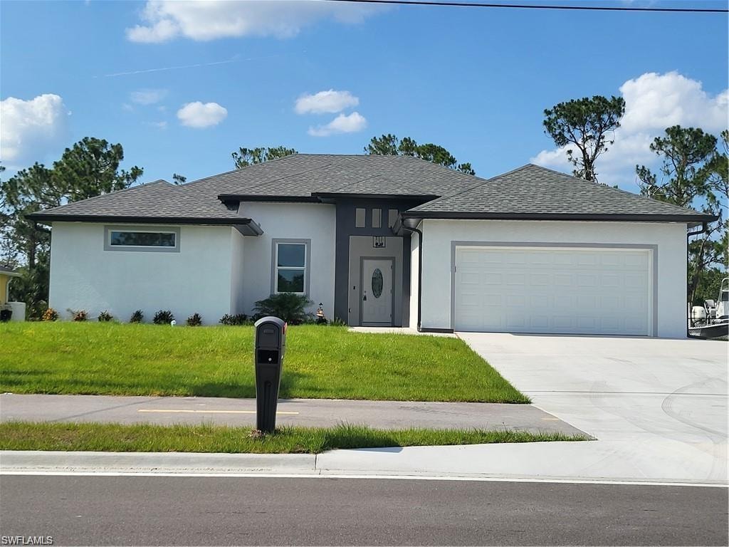 View of front of home featuring a garage and a front yard