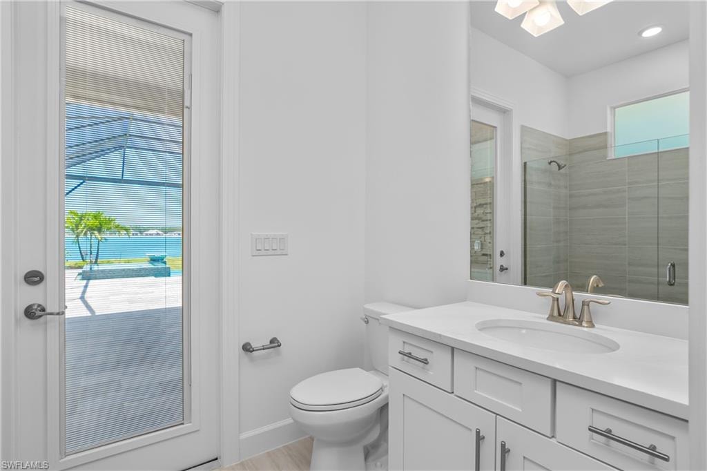 Bathroom featuring vanity, toilet, and an enclosed shower
