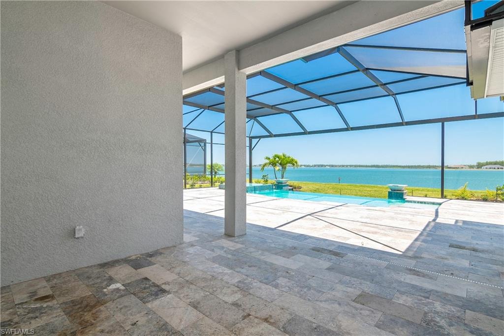 View of swimming pool featuring a patio, a water view, and a lanai