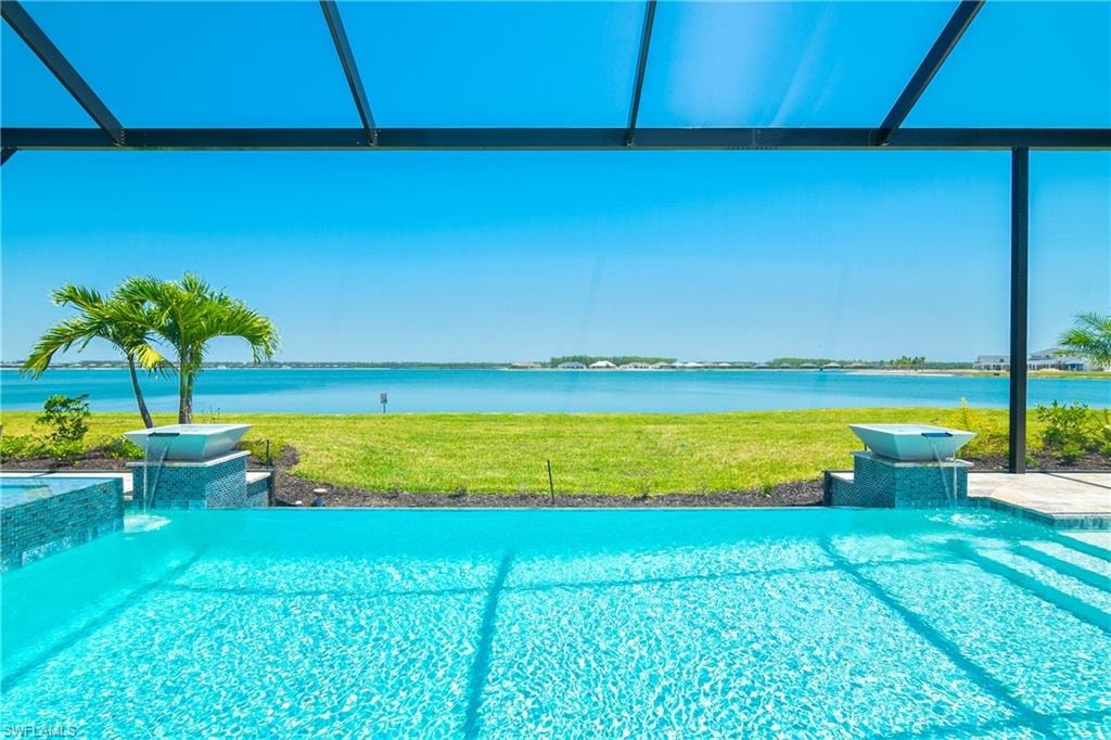 View of pool featuring a lanai, pool water feature, and a water view