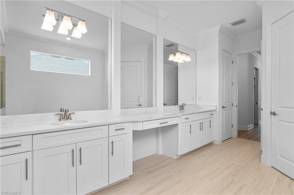 Bathroom featuring crown molding, vanity, and hardwood / wood-style flooring