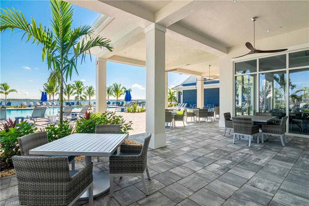 View of patio / terrace with ceiling fan and a water view