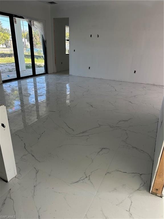 Spare room featuring light marble finish floors