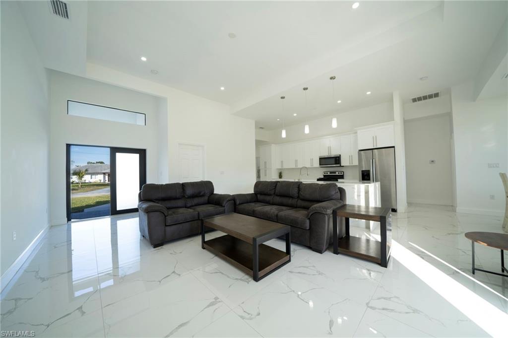 Living room featuring sink and a high ceiling
