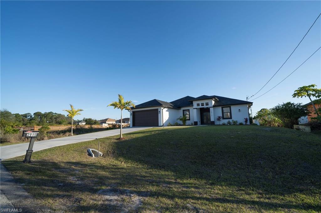 View of front of home featuring a garage and a front lawn