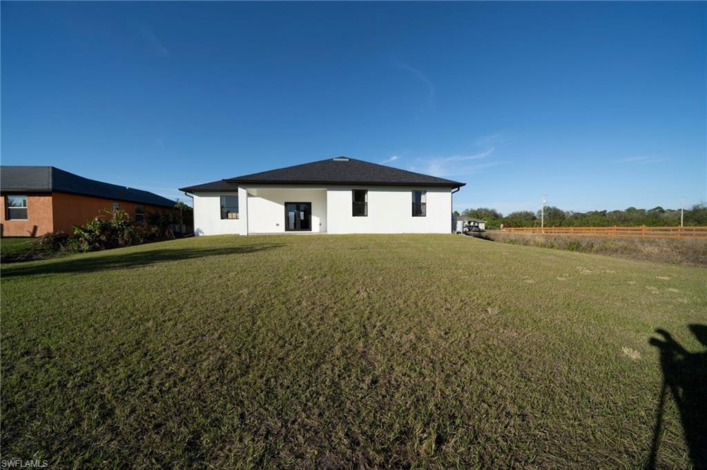Back of property featuring a lawn