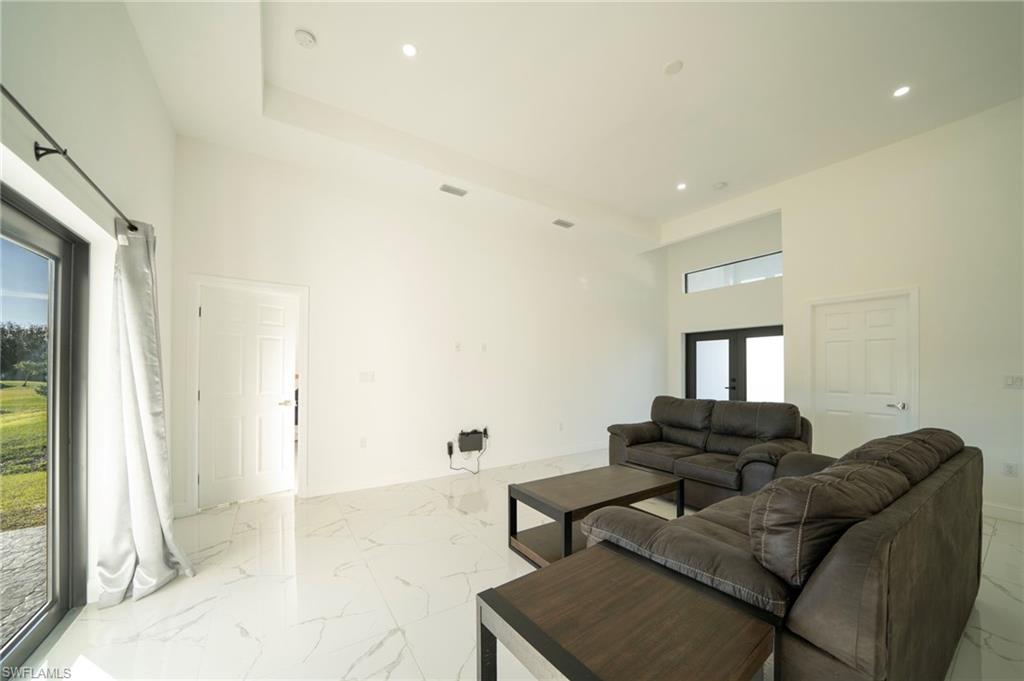 Living room featuring french doors and a high ceiling