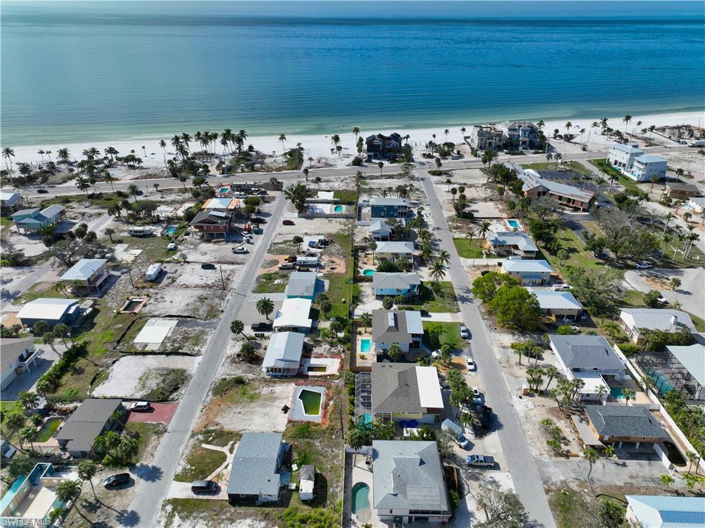 Birds eye view of property featuring a water view and a beach view