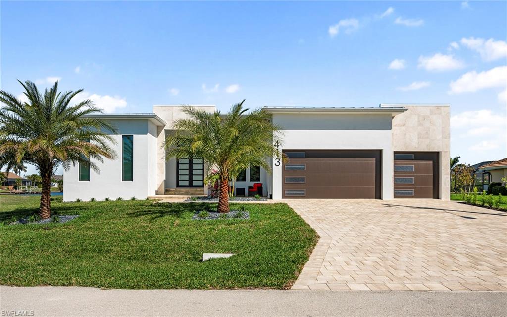 Contemporary home with stucco siding, driveway, an attached garage, and a front yard