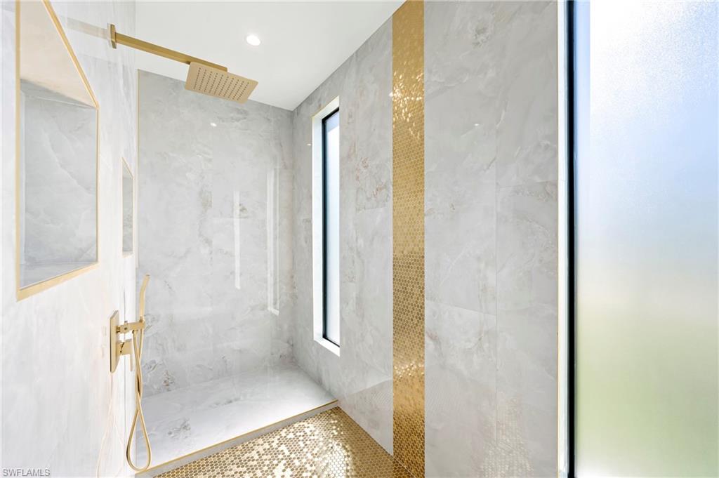 Full bath with a marble finish shower and visible vents