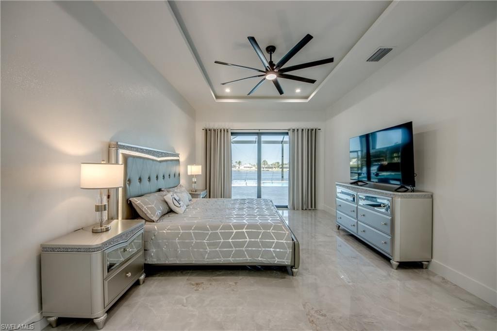 Bedroom featuring a tray ceiling and ceiling fan