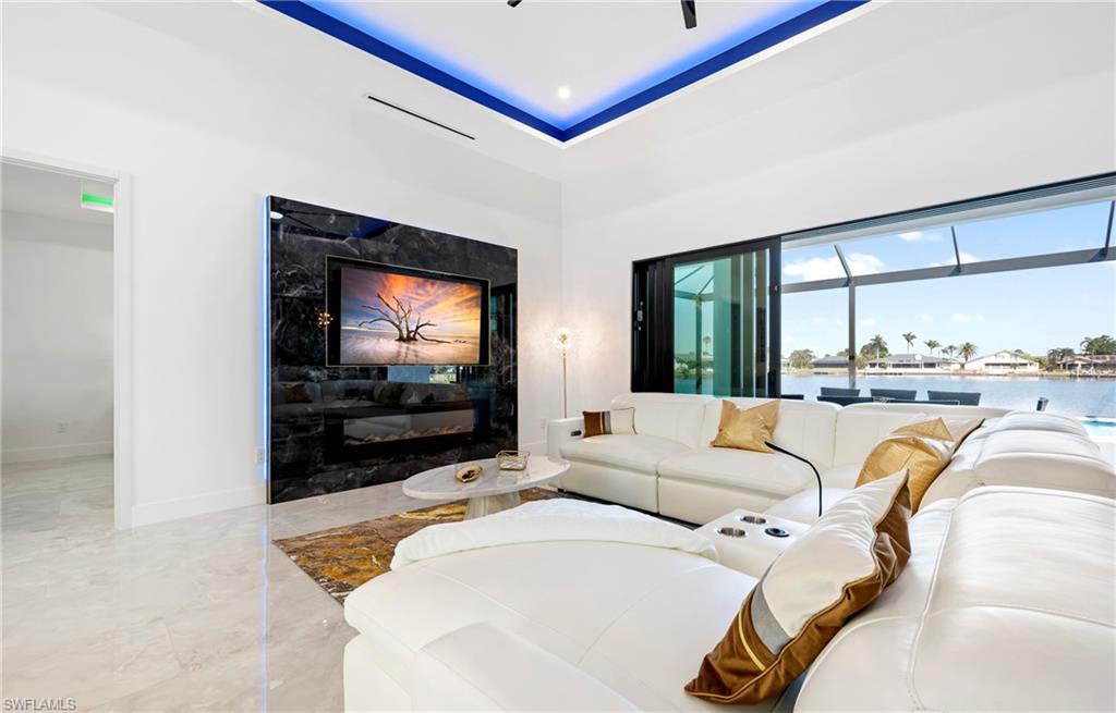 Living room with marble finish floor, baseboards, a water view, and a premium fireplace