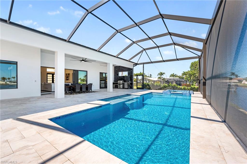 View of pool with a lanai, ceiling fan, a pool with connected hot tub, and a patio